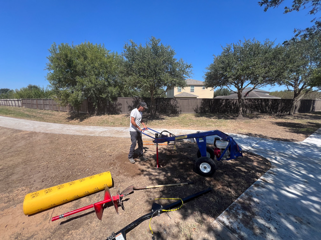 a man using a post-hole digger
